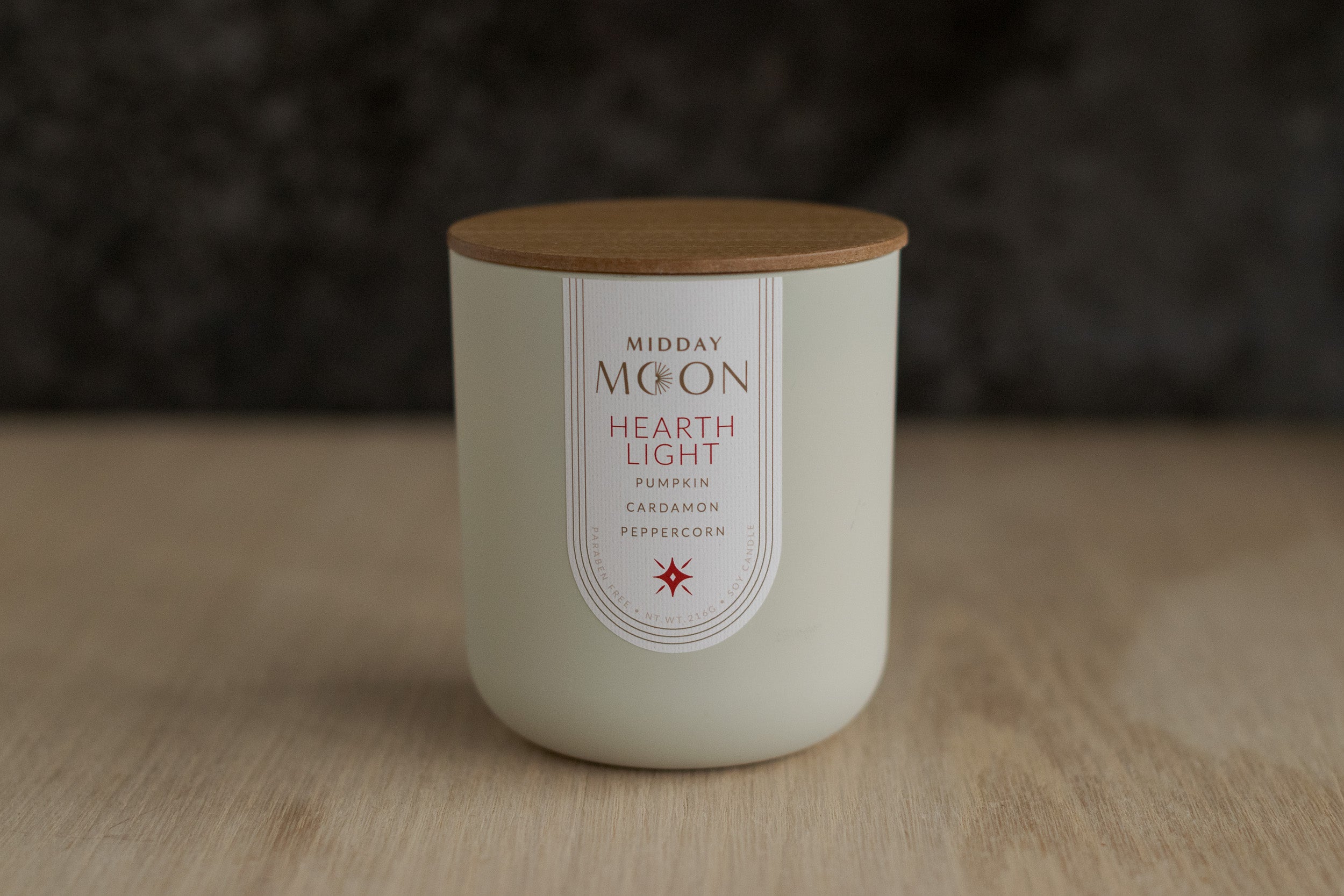 Hearthlight candle displayed on a plain wooden surface.