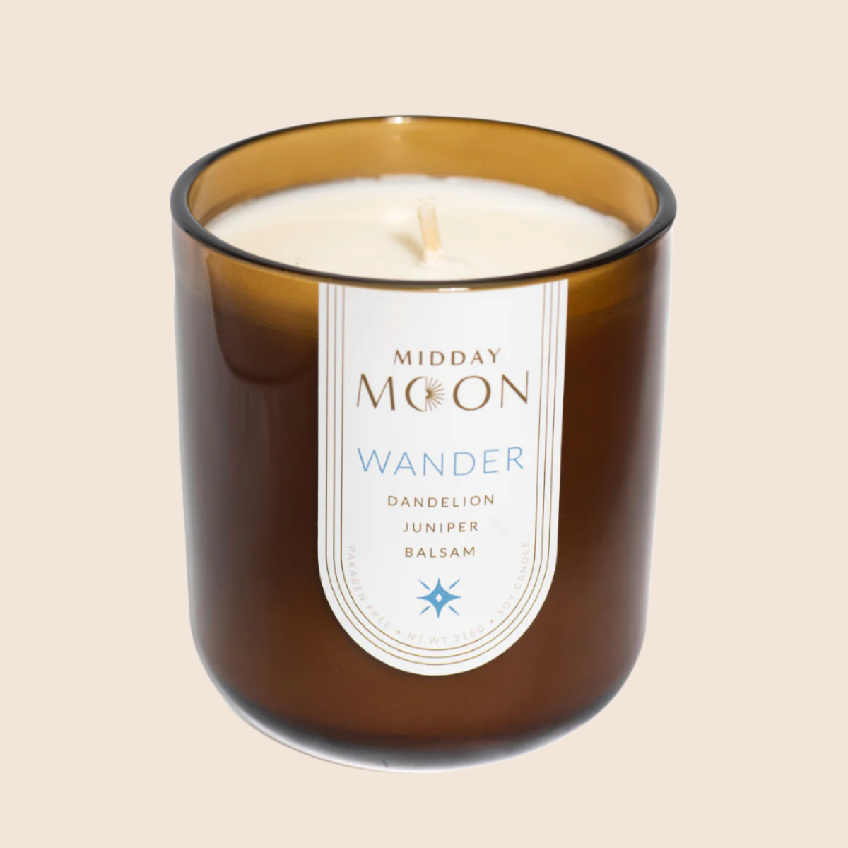 Wander scented soy candle on a plain backdrop. Dandelion, juniper, and balsam scented candle.
